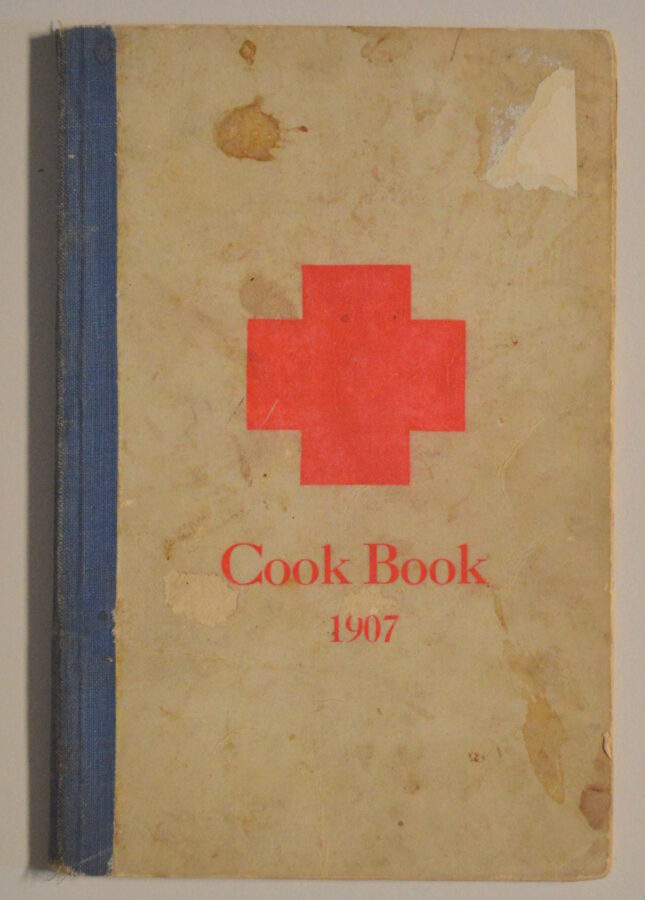 Cover of a 1907 cookbook with a red cross on the front.