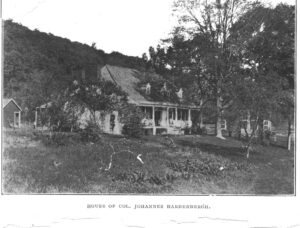 Black and white postcard showing home among trees with caption "House of Col. Johannes Hardenbergh."