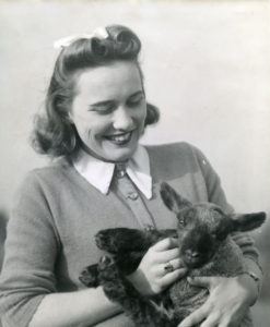 1950s photograph of a woman holding a lamb.